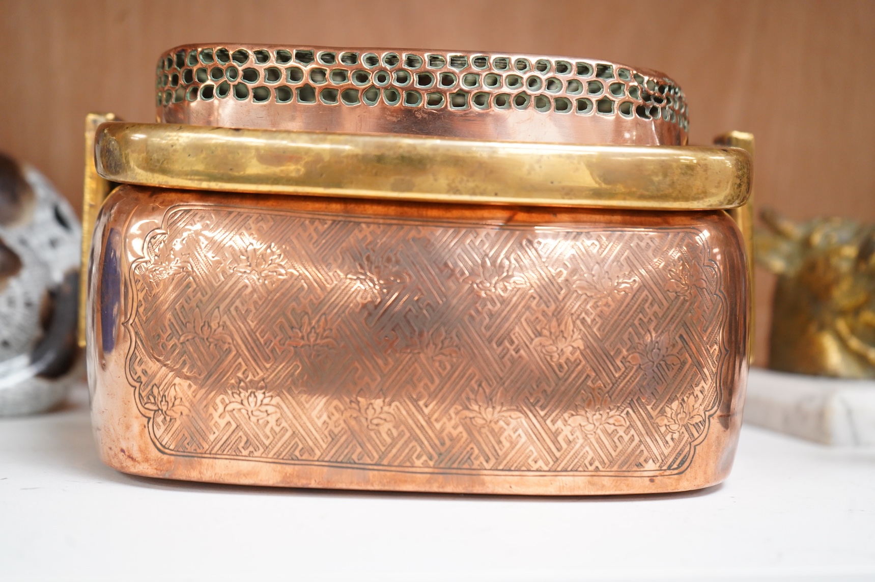 An 18th century Chinese engraved copper handwarmer with brass swing handle, 21cm wide